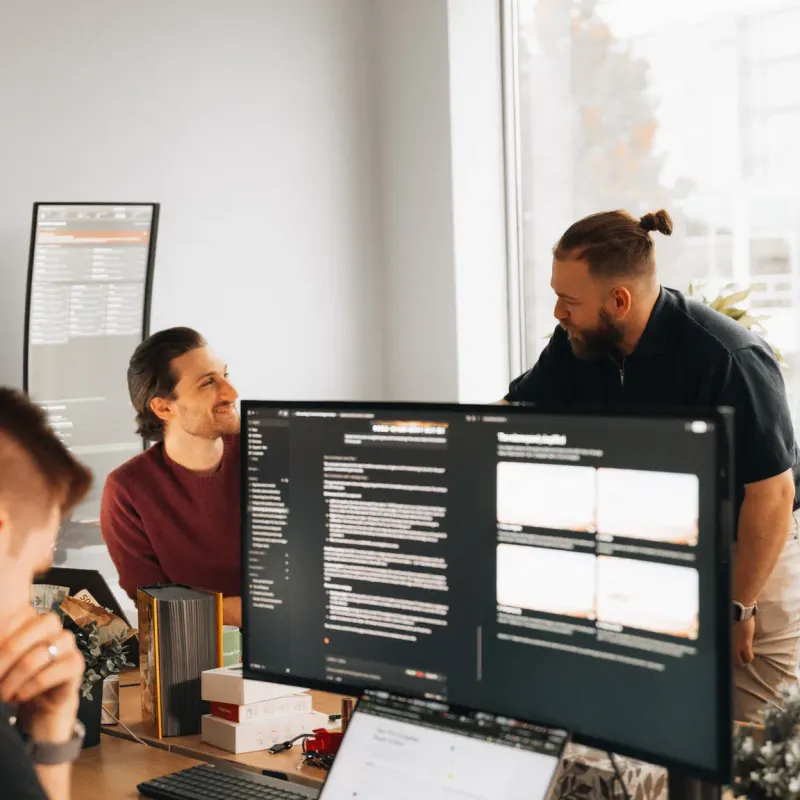 The Setsail team at their desks in the Vancouver office, talking through work on the monitors