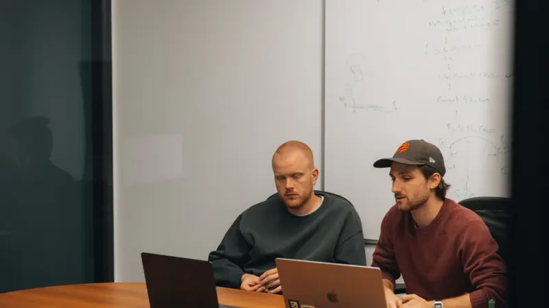 Two Setsail team members working at their laptops