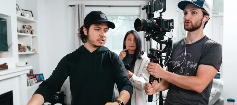 A Setsail crew mid-shoot in a bright living room, one of them holding a camera on a stabiliser rig