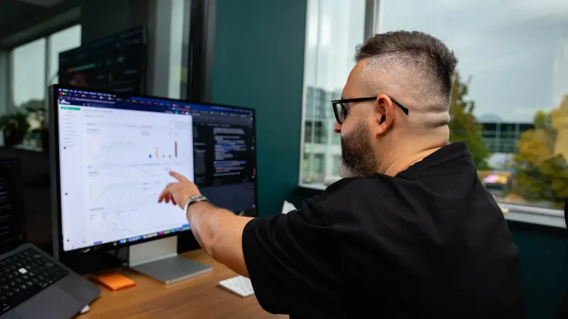 A Setsail strategist pointing out a trend in an analytics report on his monitor.